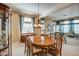 Bright dining room features a large wooden table, chandelier, and access to living room at 21413 N 159Th Dr, Sun City West, AZ 85375