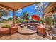 Relaxing covered patio with seating area, umbrella, and golf course view at 21413 N 159Th Dr, Sun City West, AZ 85375