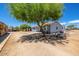 Ranch-style house with a large tree in the front yard at 21543 W Church Ave, Wittmann, AZ 85361