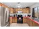 Kitchen features wood cabinets, stainless steel appliances, and red countertops at 21543 W Church Ave, Wittmann, AZ 85361