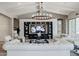 Elegant living room featuring white sofas, a large TV, and a stunning chandelier at 2351 E Cherrywood Pl, Chandler, AZ 85249