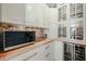 Kitchen pantry with wood countertop, glass-front cabinets, and appliances at 2351 E Cherrywood Pl, Chandler, AZ 85249