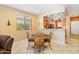 Bright dining area with wood table and chairs, adjacent to kitchen at 26171 W Via Del Sol Dr, Buckeye, AZ 85396