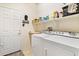 Bright laundry room with washer, dryer, and shelving at 26171 W Via Del Sol Dr, Buckeye, AZ 85396