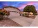 House exterior featuring a two-car garage and desert landscaping at 26222 W Behrend Dr, Buckeye, AZ 85396