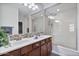 Double vanity bathroom with walk-in shower and wood cabinets at 28210 N Gedona Way, San Tan Valley, AZ 85143