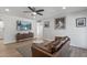 Bright living room with hardwood floors, a brown leather sofa, and modern decor at 2826 E Victor Hugo Ave, Phoenix, AZ 85032