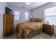 Bedroom with wooden furniture and patterned bedding at 40112 W Catherine Dr, Maricopa, AZ 85138