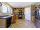 Kitchen boasts wood cabinets, tiled floors, and a stainless steel refrigerator at 40112 W Catherine Dr, Maricopa, AZ 85138