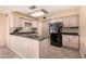 Galley kitchen with black appliances and wood cabinets at 4321 W Greenway Rd, Glendale, AZ 85306