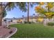 Large backyard with grassy lawn, fire pit, and mature trees at 4591 E Calle Ventura --, Phoenix, AZ 85018