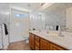 Bathroom with double sinks, a tub, and stylish wallpaper at 46108 W Tulip Ln, Maricopa, AZ 85139