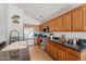 Kitchen with wood cabinets, granite countertops, and a farmhouse sink at 46108 W Tulip Ln, Maricopa, AZ 85139