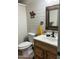 Bathroom with wood vanity, decorative mirror, and toilet at 50134 W Gail Ln, Maricopa, AZ 85139