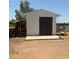 White storage shed with dark brown double doors and concrete slab at 50134 W Gail Ln, Maricopa, AZ 85139