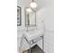 Clean bathroom with white subway tiles, pedestal sink, and a framed mirror at 5989 E Sapphire Ln, Paradise Valley, AZ 85253