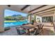 Outdoor patio with a dining table and chairs overlooking a sparkling pool and mountain views at 5989 E Sapphire Ln, Paradise Valley, AZ 85253