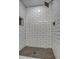 Clean shower with white subway tile walls and a dark-grey penny tile floor at 6017 E Beck Ln, Scottsdale, AZ 85254