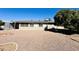 Wide backyard featuring gravel landscape and a view of the house exterior with windows and a large tree for shade at 6449 E Dodge St, Mesa, AZ 85205