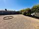 Backyard featuring gravel landscaping, defined landscaping circles, a block fence, and a green hedge providing privacy at 6449 E Dodge St, Mesa, AZ 85205