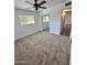 Bedroom featuring new carpeting, large window and modern ceiling fan at 6449 E Dodge St, Mesa, AZ 85205