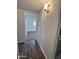 Hallway with tile flooring and a view into the bedroom with white walls and ceiling fan at 6449 E Dodge St, Mesa, AZ 85205