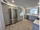 Newly updated kitchen with stainless steel refrigerator, gray cabinetry, and vinyl flooring at 6449 E Dodge St, Mesa, AZ 85205