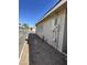 Side yard view, displaying access and brick-wall construction with utility hardware and a partial glimpse of the surrounding area at 6449 E Dodge St, Mesa, AZ 85205