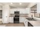 Modern kitchen with white cabinets, stainless steel appliances, and tile floors at 6612 W Paso Trl, Phoenix, AZ 85083