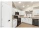 Modern kitchen with white cabinets, stainless steel appliances, and tile floors at 6612 W Paso Trl, Phoenix, AZ 85083