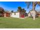 Spacious backyard with green grass, patio space, red chairs, and a white shed at 6811 N 11Th Ave, Phoenix, AZ 85013