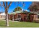 Charming brick home with a manicured lawn and cozy porch seating arrangement at 6811 N 11Th Ave, Phoenix, AZ 85013