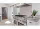 Close up of stainless steel stove and hood, with granite countertops and herringbone backsplash at 6811 N 11Th Ave, Phoenix, AZ 85013