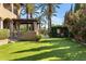 Manicured backyard with green lawn, trees, and stone structures near a luxury home with arched loggia at 6876 S Star Dr, Gilbert, AZ 85298