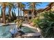 Beautiful backyard features a swimming pool, spa, lush landscaping, outdoor seating, and palm trees at 6876 S Star Dr, Gilbert, AZ 85298