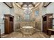 Luxurious bathroom featuring a tub with an exquisite stone surround and decorative chandelier at 6876 S Star Dr, Gilbert, AZ 85298