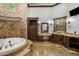 Luxurious bathroom featuring a tub with a stone surround, decorative chandelier, and vanity at 6876 S Star Dr, Gilbert, AZ 85298