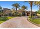 Paver driveway leads to an estate home with manicured grounds, palms and wrought iron entry gate at 6876 S Star Dr, Gilbert, AZ 85298