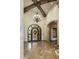 Grand foyer with ironwork door, stone columns, tile floors and a decorative chandelier at 6876 S Star Dr, Gilbert, AZ 85298