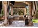 Outdoor kitchen with stone columns, wood pergola, built-in stainless steel appliances, grill, and bar seating at 6876 S Star Dr, Gilbert, AZ 85298