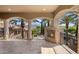 Covered outdoor patio with a fireplace, pillars, and views of the pool and palm trees at 6876 S Star Dr, Gilbert, AZ 85298