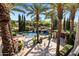 Aerial view of a luxury pool and spa with a waterfall feature and a cabana with patio furniture and palm trees at 6876 S Star Dr, Gilbert, AZ 85298