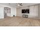 Spacious living room featuring wood-look tile flooring and a large TV at 6924 W Southgate Ave, Phoenix, AZ 85043