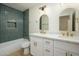 Spa-like bathroom with a green tiled shower and double vanity at 7432 E Latham St, Scottsdale, AZ 85257