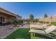 Landscaped backyard with patio, artificial turf, and lounge chairs at 8202 W Merriweather Way, Florence, AZ 85132