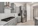 Modern kitchen features gray cabinets, stainless steel appliances, and hexagon backsplash at 8202 W Merriweather Way, Florence, AZ 85132