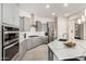 Modern kitchen with gray cabinets, stainless steel appliances, and white quartz countertops at 8202 W Merriweather Way, Florence, AZ 85132