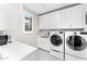 Bright laundry room with white cabinets and modern washer and dryer at 9630 E Mountain Spring Rd, Scottsdale, AZ 85255