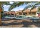 Home's backyard features a kidney-shaped pool, patio, and palm trees at 1007 W Armstrong Way, Chandler, AZ 85286