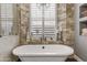 Relaxing bathroom with a free-standing tub and a large window at 1007 W Armstrong Way, Chandler, AZ 85286